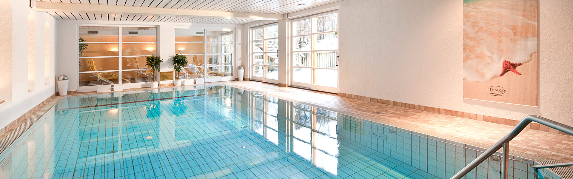 Ansicht eines Indoor-Pools in einem hellen, hochwertigen Resort-Raum
