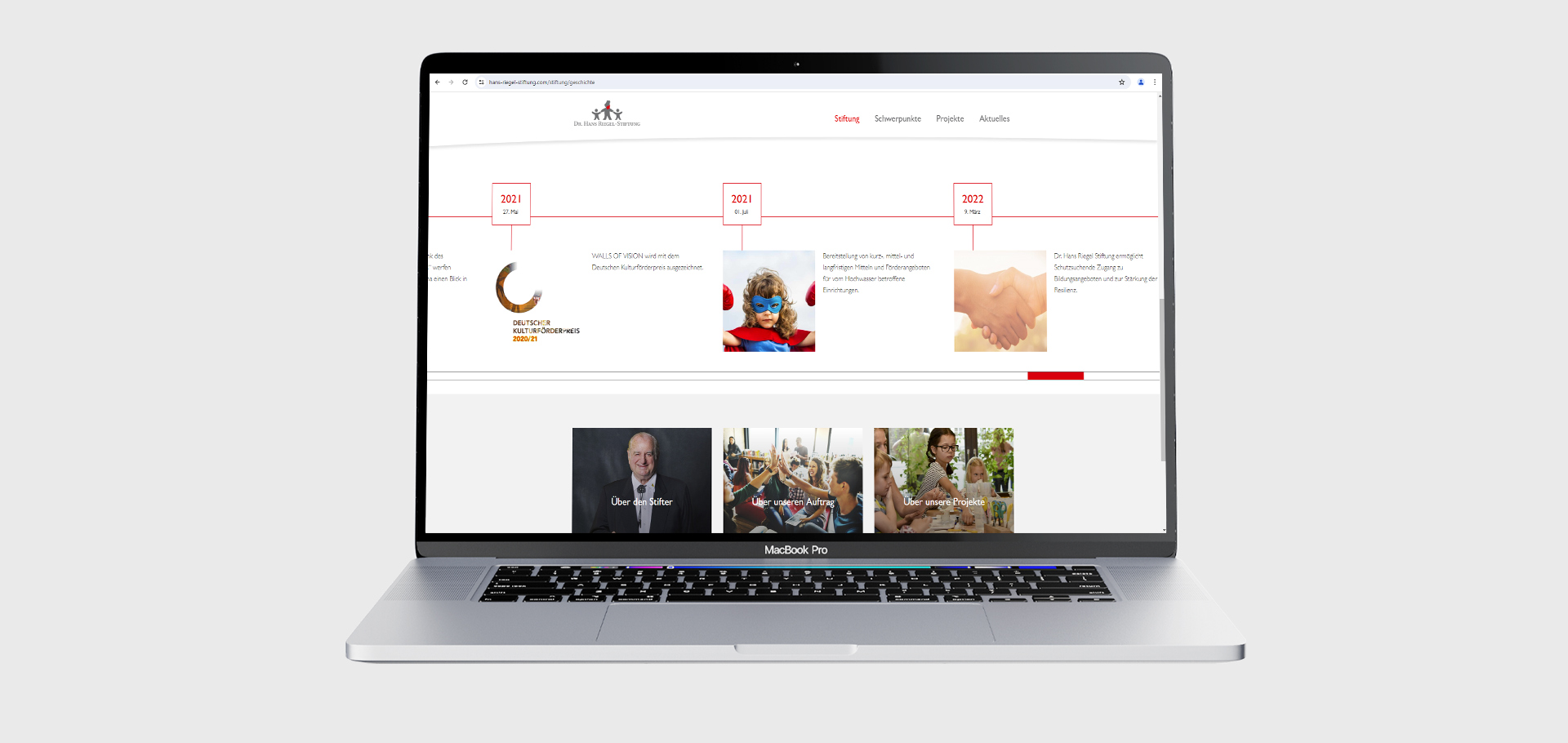 Ansicht der Webseite der Dr. Hans-Riegel-Stiftung auf einem Notebook vor grauem Hintergrund