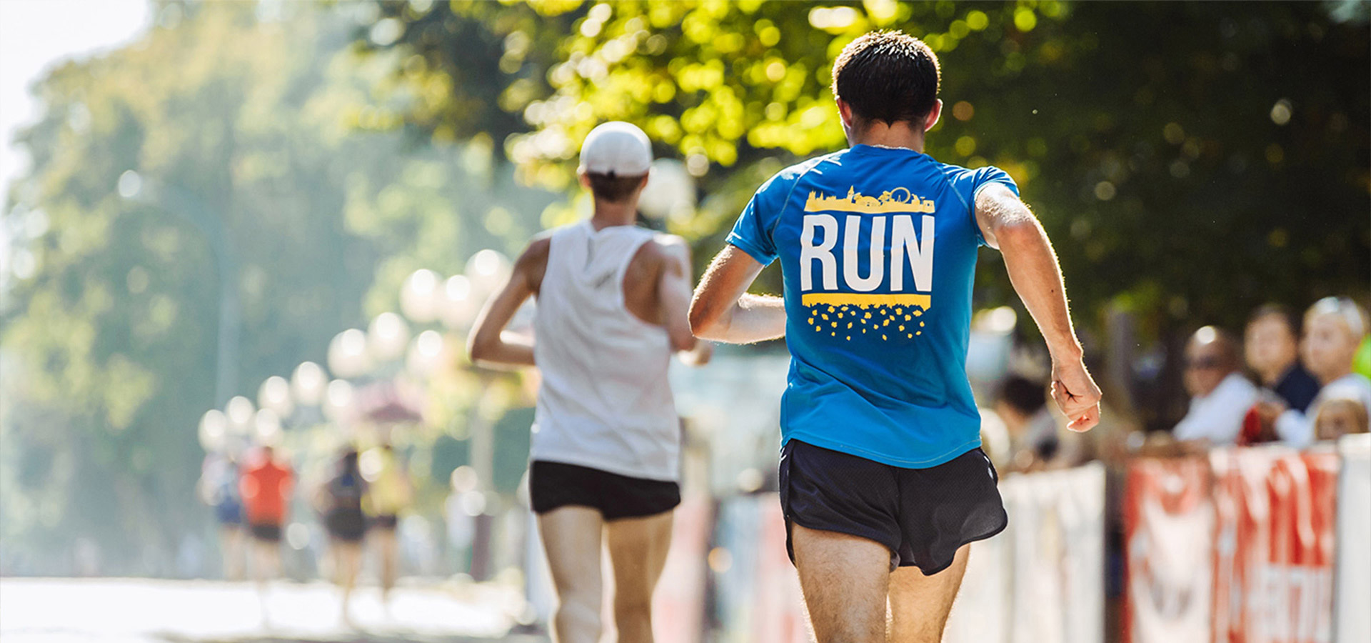 Zwei Läufer mitten in der Bewegung von hinten, die an einem Marathon teilnehmen