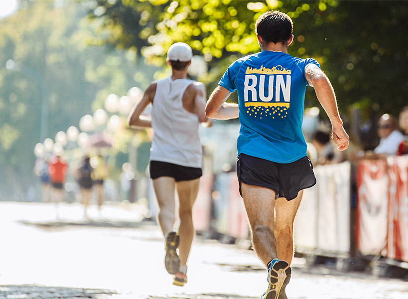 Zwei Läufer mitten in der Bewegung von hinten, die an einem Marathon teilnehmen
