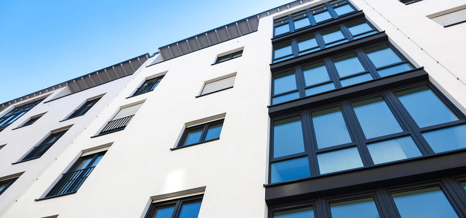 Aufnahme eines modernen mehrstöckiges Gebäudes mit weißen Wänden und schwarzen Fensterrahmen von unten