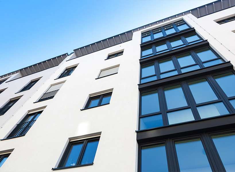 Aufnahme eines modernen mehrstöckiges Gebäudes mit weißen Wänden und schwarzen Fensterrahmen von unten
