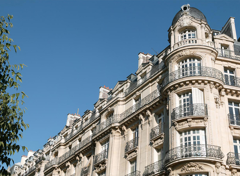 Historisches Gebäude mit kunstvollen architektonischen Details und Balkone mit schmiedeeisernen Geländern