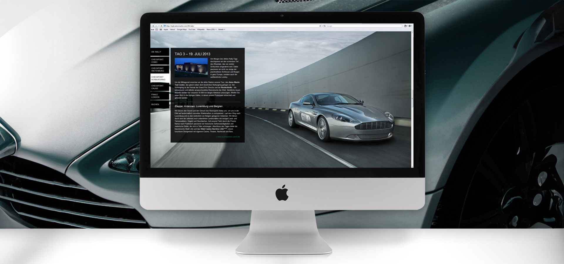 Ansicht der Website der 100 Jahre Aston Martin Europa Rally auf einem MacBook vor einer Nahaufnahme eines silbernen Sportwagens