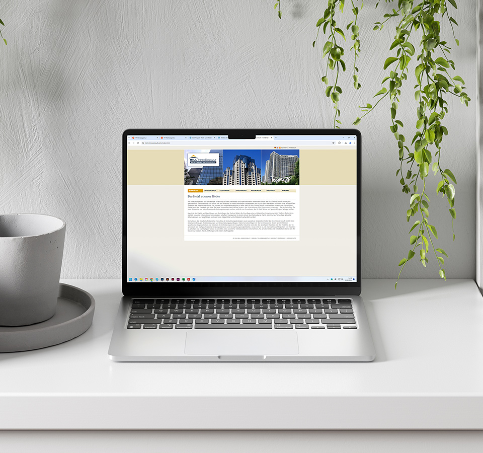 Ansicht der Webseite von BILL ImmoConsult auf einem Notebook in einem modern eingerichteten Zimmer mit Pflanzen