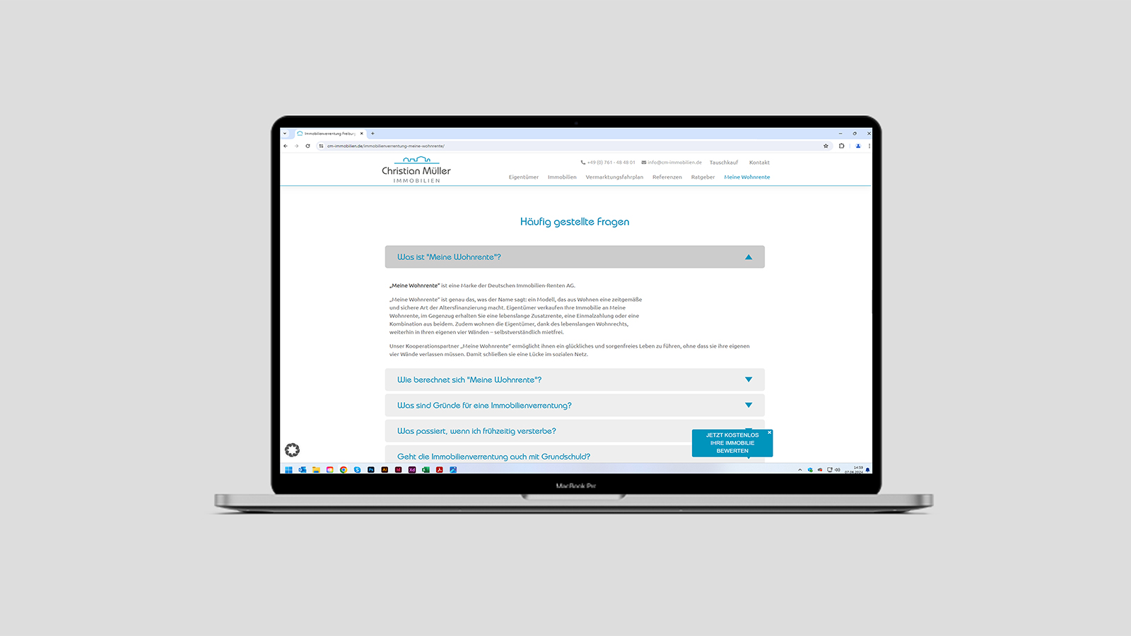 Ansicht einer Unterseite der Webseite von Christian Müller Immobilien auf einem Notebook vor grauem Hintergrund