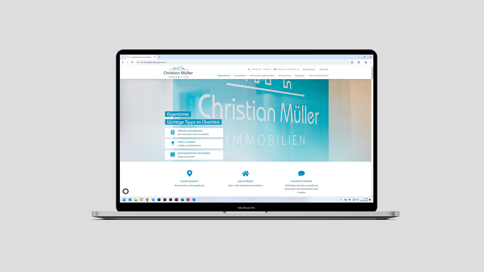 Ansicht einer Unterseite der Webseite von Christian Müller Immobilien auf einem Notebook vor grauem Hintergrund