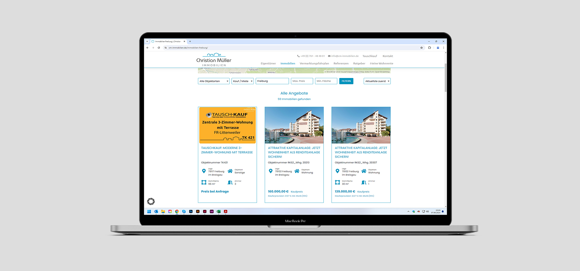 Ansicht einer Unterseite der Webseite von Christian Müller Immobilien auf einem Notebook vor grauem Hintergrund