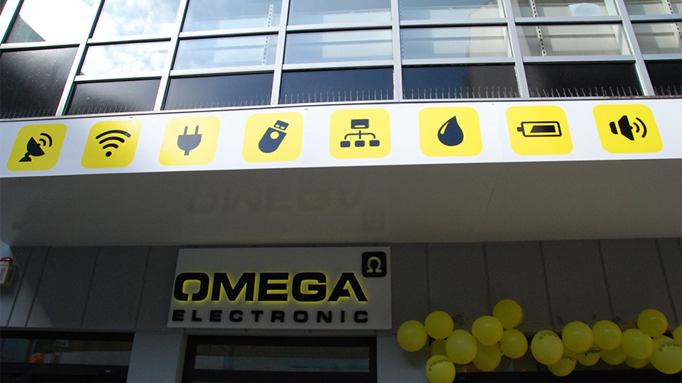 Ansicht der Front der Filiale von Omega Electronics aus der Froschperspektive mit Icons im Corporate Design