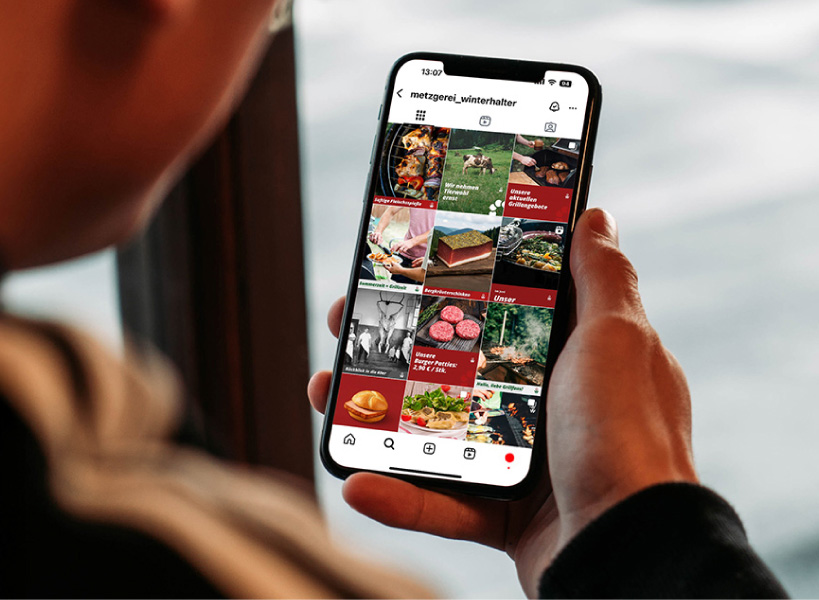 Mann, welcher ein iPhone mit dem Instagram-Profil von Gustav Winterhalter in der Hand hält